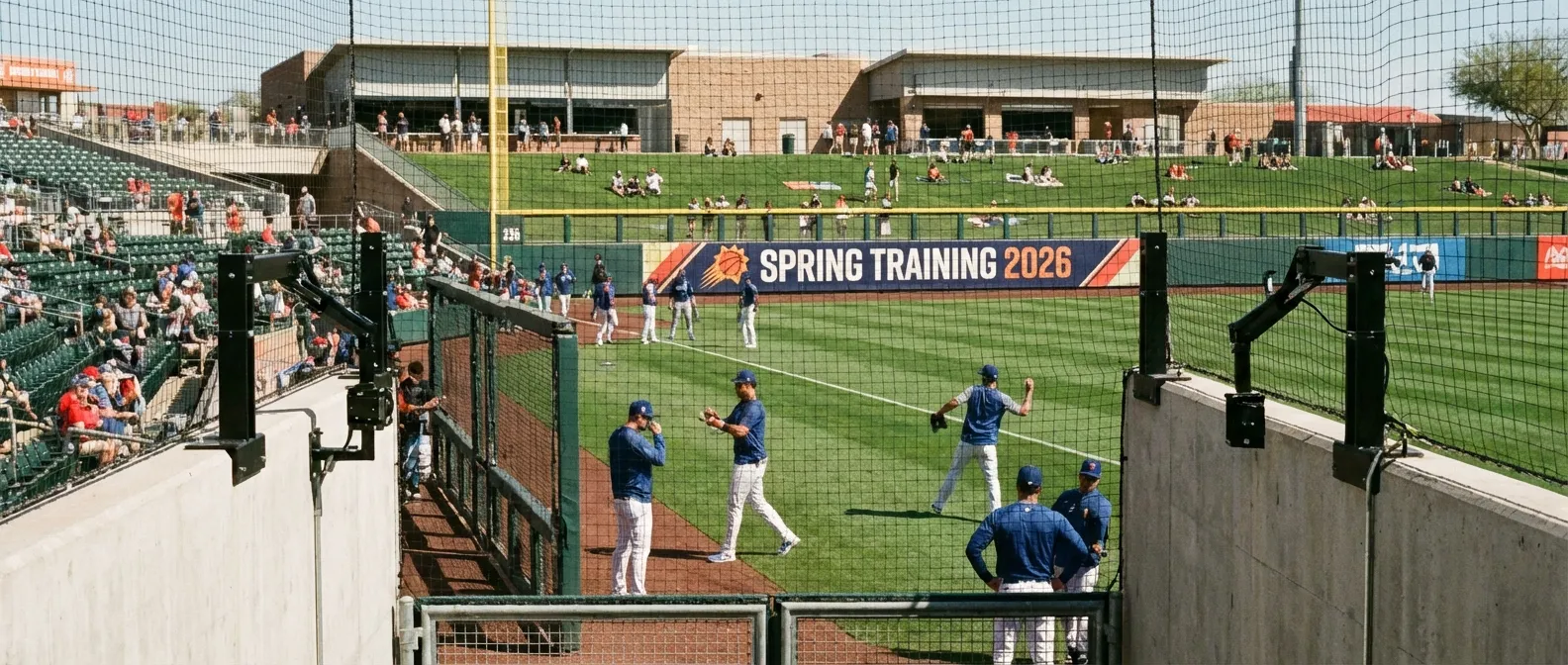 Players warming up at a spring training facility with Hawk-Eye technology infrastructure visible